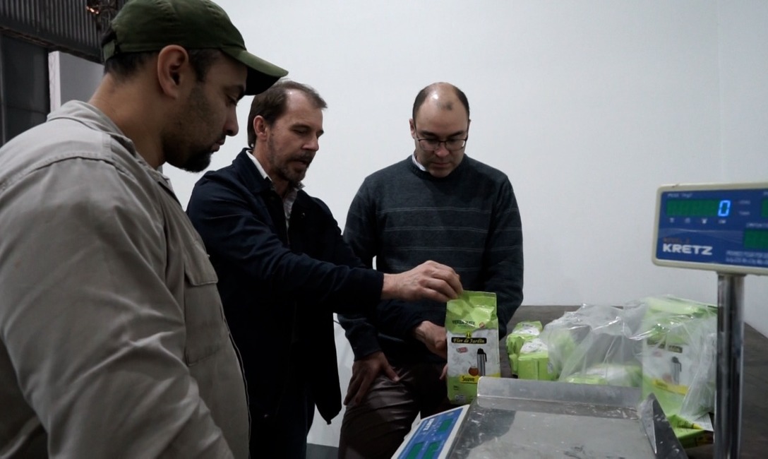 El presidente de la cooperativa (al centro), el gerente comercial y un operario ajustan detalles en el área de envasado.